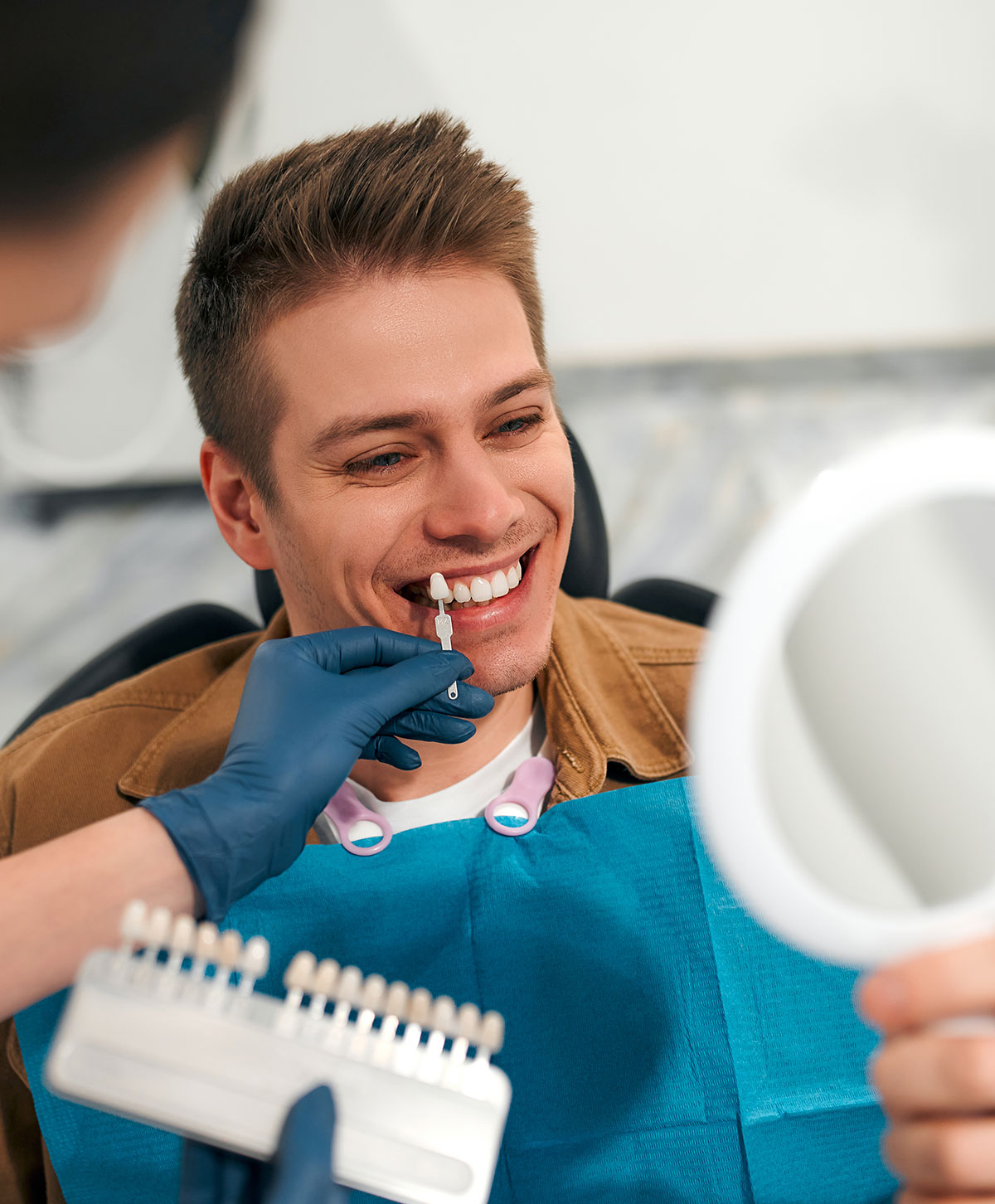 Ragazzo guarda i suoi denti per l'applicazione di faccette dentali